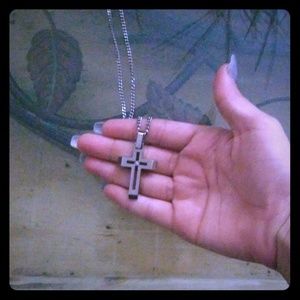 A silver chain with a cross on it. ✌